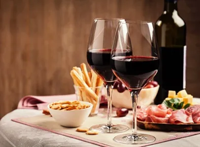 Deux verres de vin rouge, pain, fromage et charcuterie sur une table à Toulouse en Haute-Garonne 31