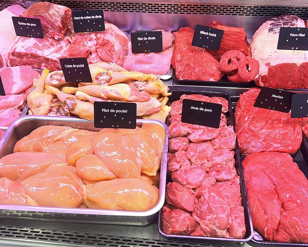 Vitrine de boucherie avec différentes coupes de viande : porc, poulet, dinde, bœuf à Toulouse en Haute-Garonne 31