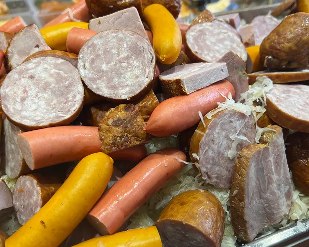 Un assortiment de saucisses, jambons et charcuteries coupés sur de la choucroute à Toulouse en Haute-Garonne 31