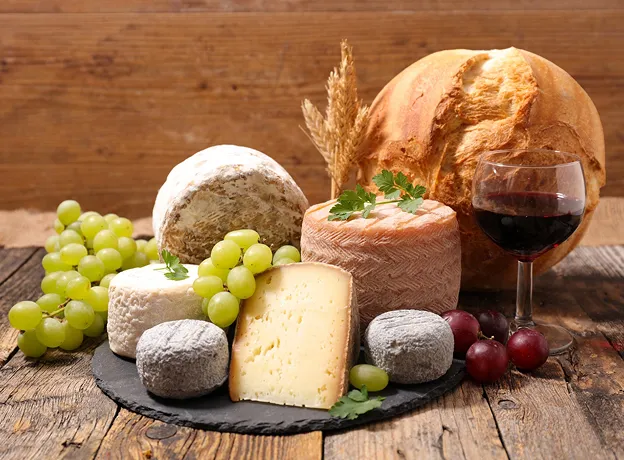 Assortiment de fromages, raisins, pain et vin rouge sur table en bois à Toulouse en Haute-Garonne 31