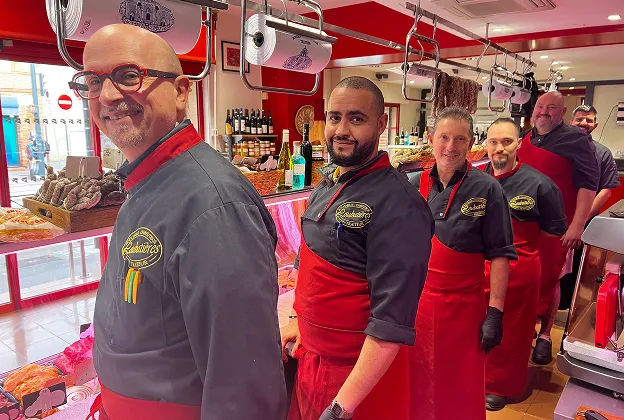 Cinq bouchers souriants en ligne dans une boucherie moderne à Toulouse en Haute-Garonne 31